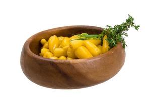 Yellow marinated pepper in a bowl on white background photo