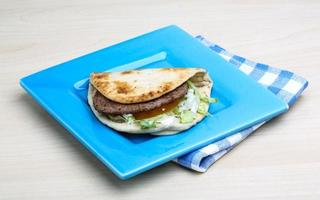 Greek pita on the plate and wooden background photo