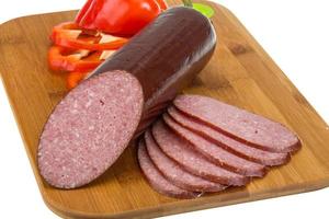 Sausages on wooden board and white background photo