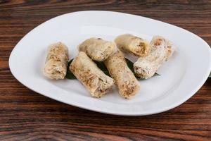 Spring rolls on the plate and wooden background photo