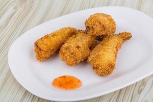 tempura de gambas fritas en el plato y fondo de madera foto