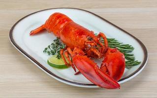 Red boiled lobster on the plate and wooden background photo