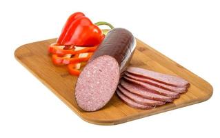 Sausages on wooden board and white background photo