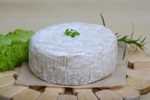 Camembert cheese on wooden board and white background photo