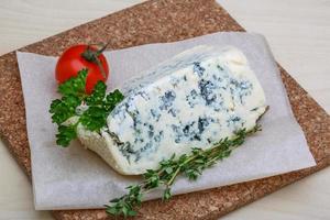 queso azul sobre tabla de madera y fondo de madera foto