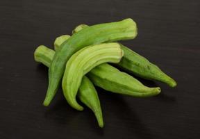 Okra vegetables on wooden background photo