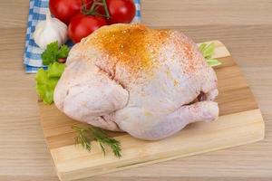 Raw chicken on wooden board and wooden background photo