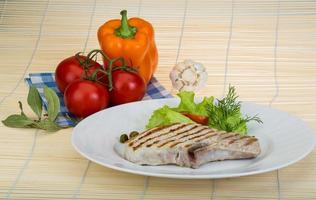 Grilled t-bone steak on the plate and wooden background photo