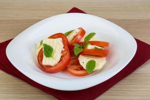 caprese en un recipiente sobre fondo de madera foto