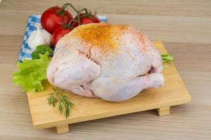 Raw chicken on wooden board and wooden background photo