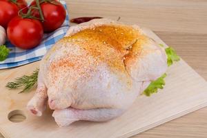 Raw chicken on wooden board and wooden background photo