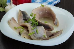 Herring fillet in a bowl on wooden background photo