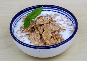 Cornfalkes desayuno en un bol sobre fondo de madera foto