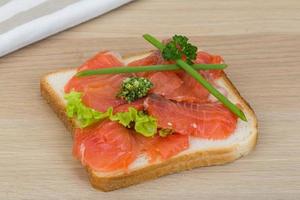 Salmon sandwich on wooden background photo