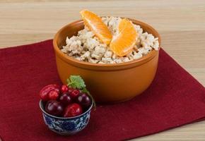 Oatmeal in a bowl on wooden background photo
