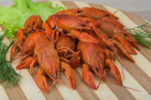 Boiled crayfish on wooden board and wooden background photo