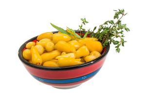 Yellow marinated pepper in a bowl on white background photo