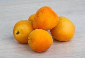 Apricots on wooden background photo