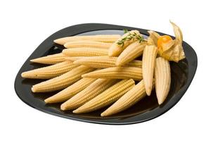 Baby corn on the plate and white background photo