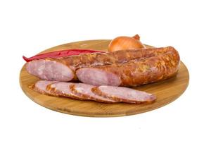 Sausages on wooden board and white background photo