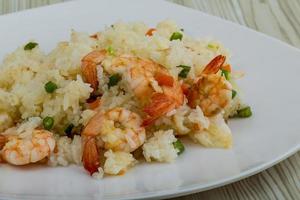 Fried rice with prawns on the plate and wooden background photo