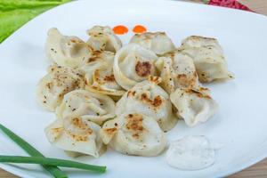 Roasted pierogi on the plate and wooden background photo