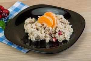 Oatmeal on the plate and wooden background photo