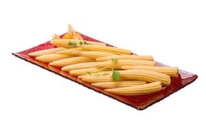 Baby corn on the plate and white background photo