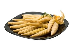 Baby corn on the plate and white background photo