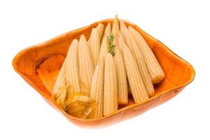 Baby corn in a bowl on white background photo