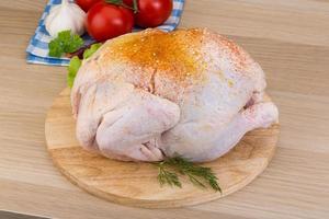 Raw chicken on wooden board and wooden background photo