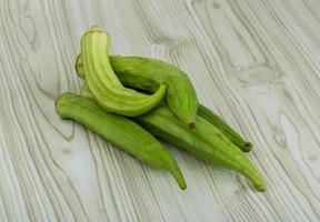 Okra vegetables on wooden background photo