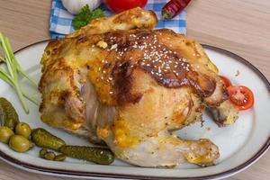 Grilled chicken on the plate and wooden background photo