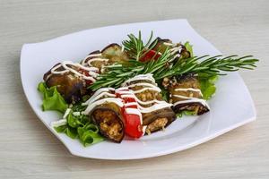 Aubergine roll on the plate and wooden background photo