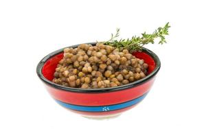 Backed lentils in a bowl on white background photo