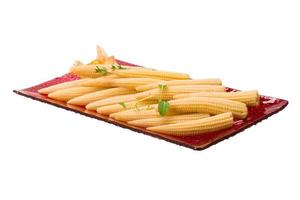 Baby corn on the plate and white background photo