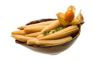 Baby corn in a bowl on white background photo