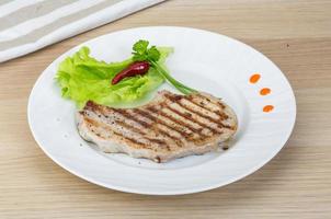 Grilled t-bone steak on the plate and wooden background photo