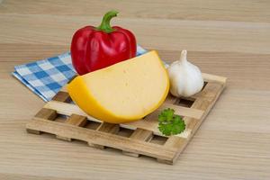 Yellow round cheese on wooden background photo