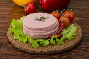 Sausage on wooden board and wooden background photo