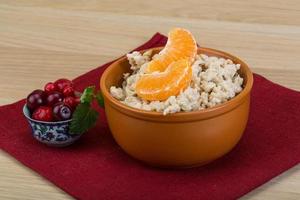 Oatmeal in a bowl on wooden background photo