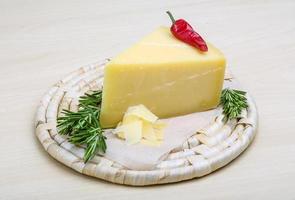 Parmesan cheese on wooden board and wooden background photo