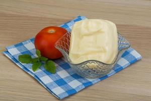 Mozzarella cheese in a bowl on wooden background photo