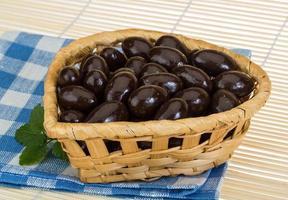 Almond in chocolate in a basket on wooden background photo