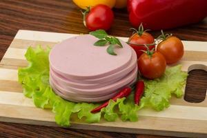 Sausage on wooden board and wooden background photo