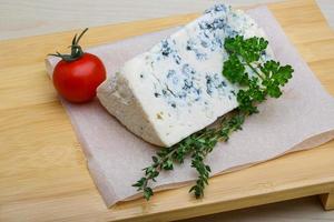 Blue cheese on wooden board and wooden background photo