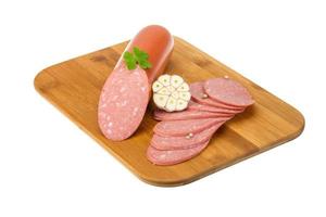 Sausages on wooden board and white background photo