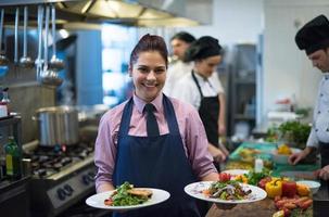 young waitress showing dishes of tasty meals photo