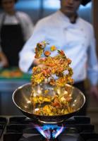 chef flipping vegetables in wok photo