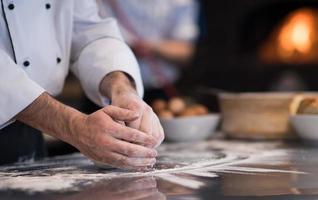 chef hands preparing dough for pizza photo